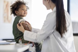 Doctor providing band aid to vaccinated child