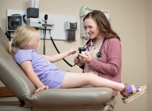 Pediatrician examines child in Dr. office